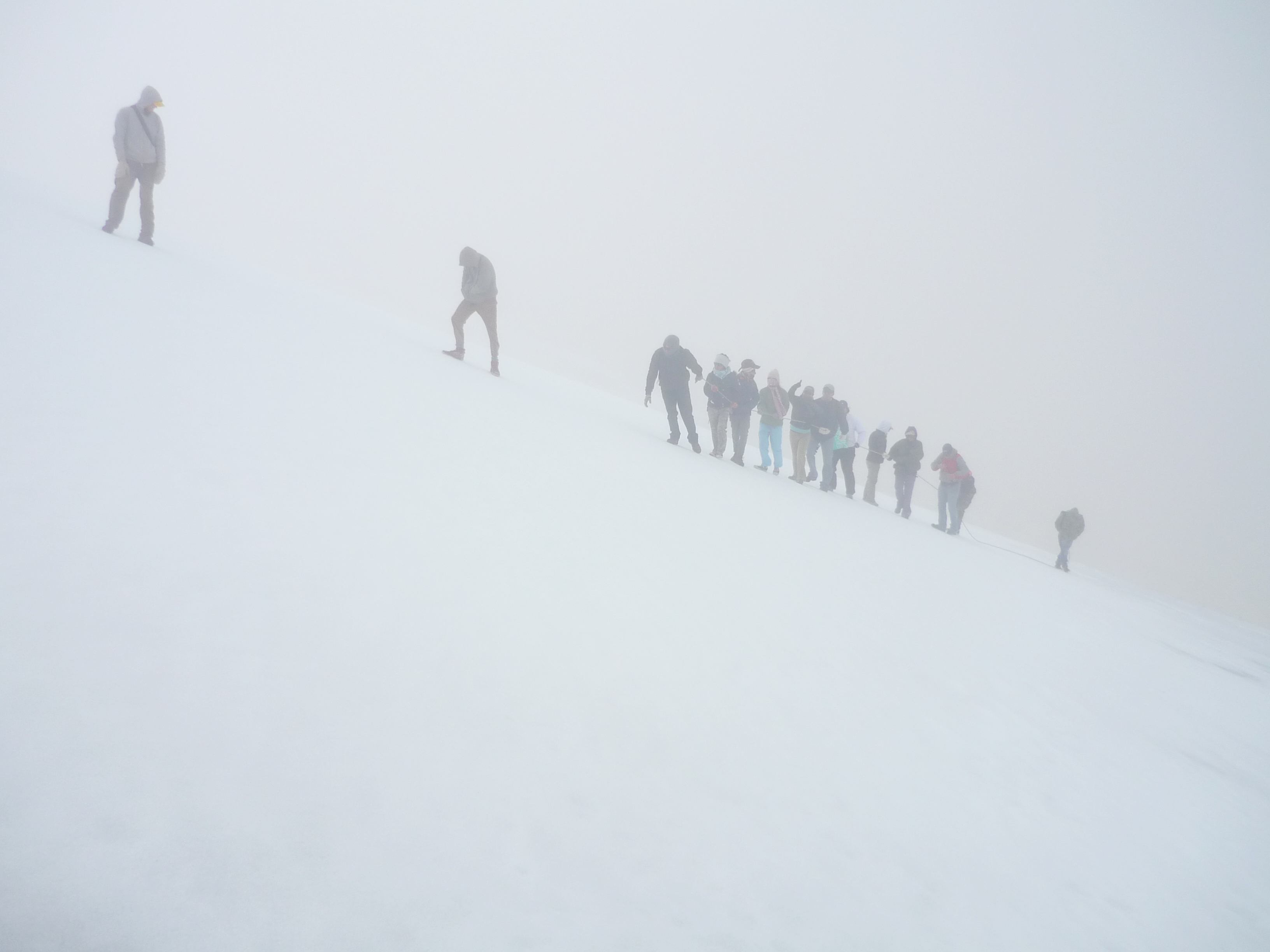 Hikers climbing the glacier in fog